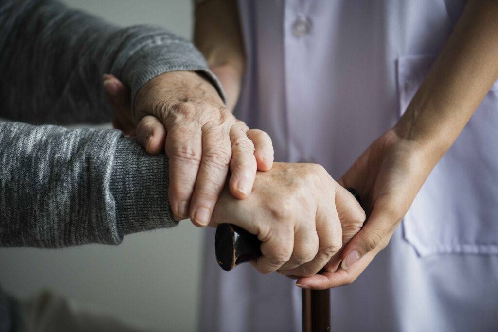 a caregiver holding hand of a patient.